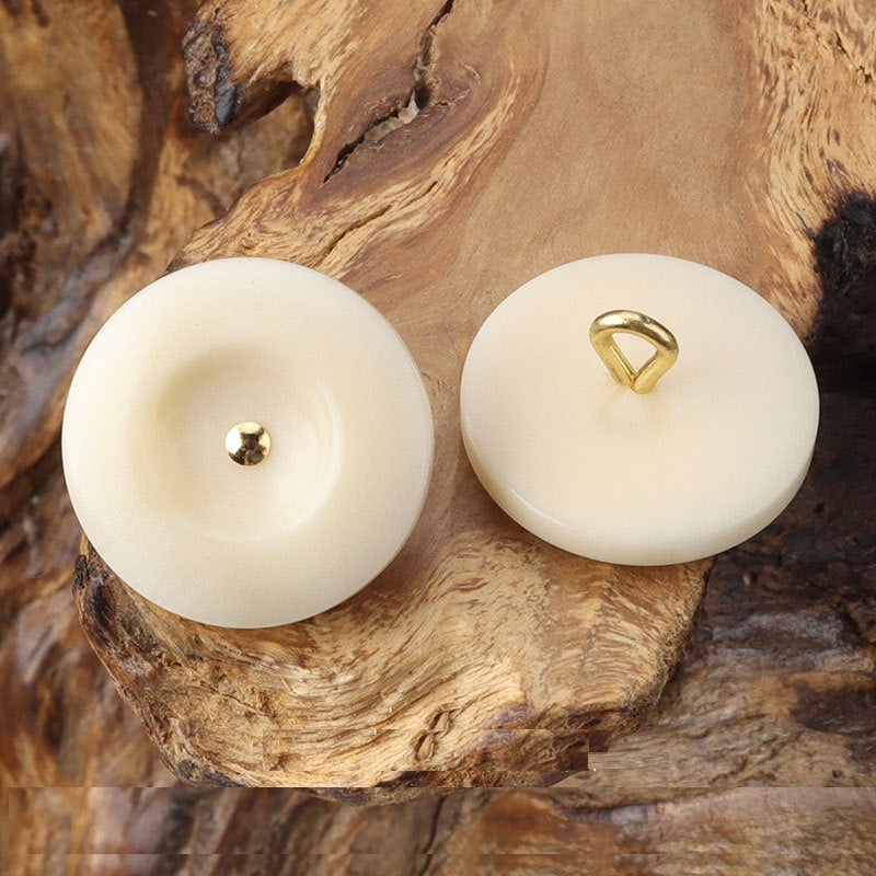 Beige/ivory round corozo shank buttons with brass shank, front view