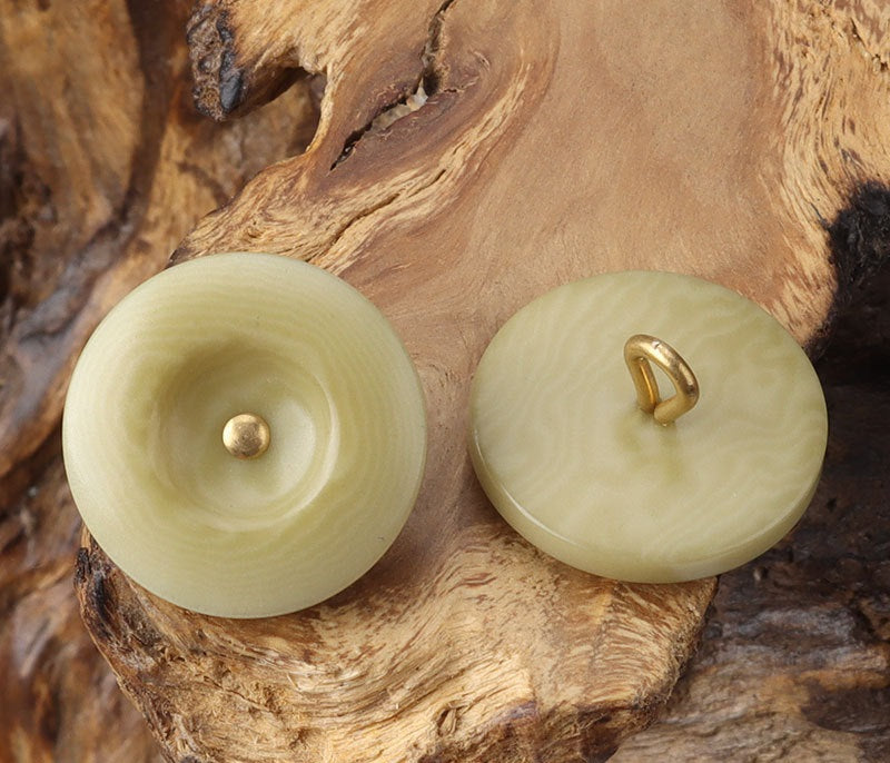 Light beige and pale green round corozo shank buttons with brass shanks, pair view
