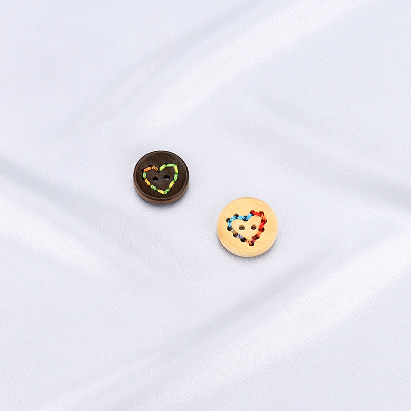 Two heart-shaped buttons with thread border: dark coffee and light wood