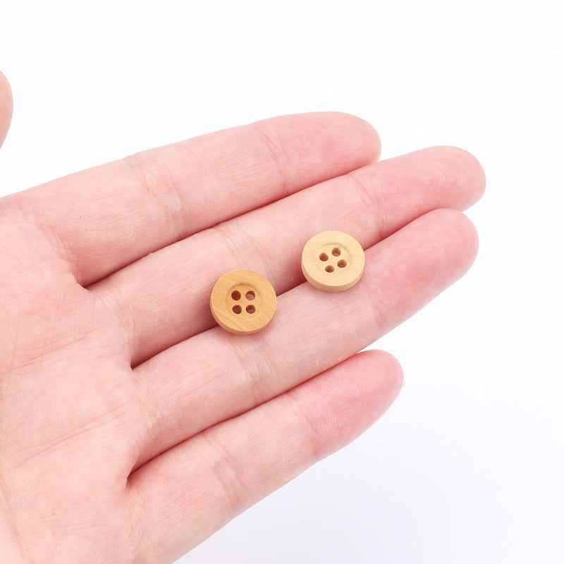 Two natural poplar 4-hole buttons (11.5mm) on open palm