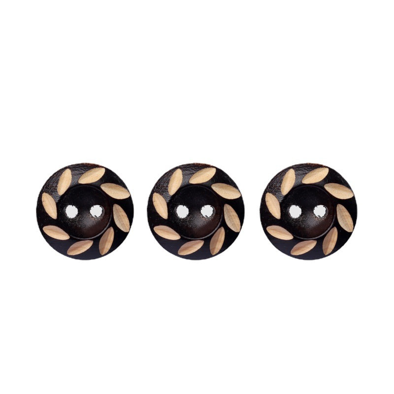Set of round 2-hole wood buttons in dark brown/black with light leaf laser-carving