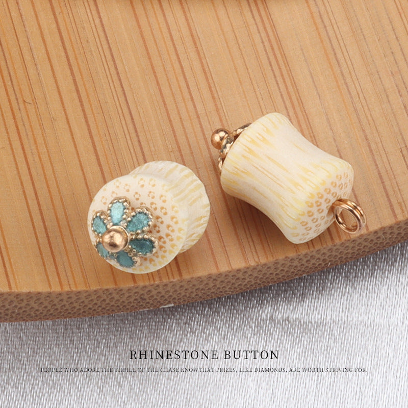Two cream bamboo frog knot buttons: round with teal flower stones and curved back with gold ring