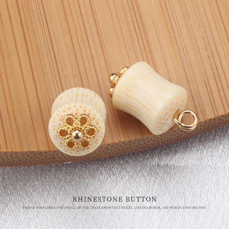 Cream bamboo frog knot button with gold flower center gem, paired with a curved back view