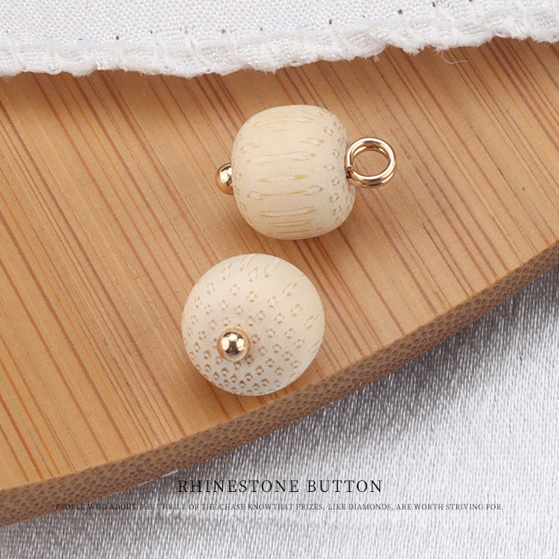 Cream bamboo frog knot buttons with gold mounts and small gem accents; one round face and one back ring