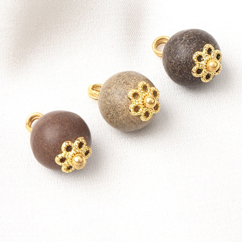 Khaki round coconut shell button with gold flower-style top and metal shank loop