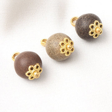 Khaki round coconut shell button with gold flower-style top and metal shank loop