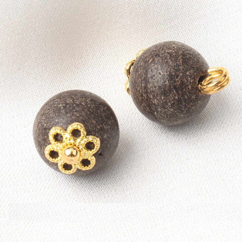 Khaki coconut shell button front with gold flower detail and visible metal shank loop