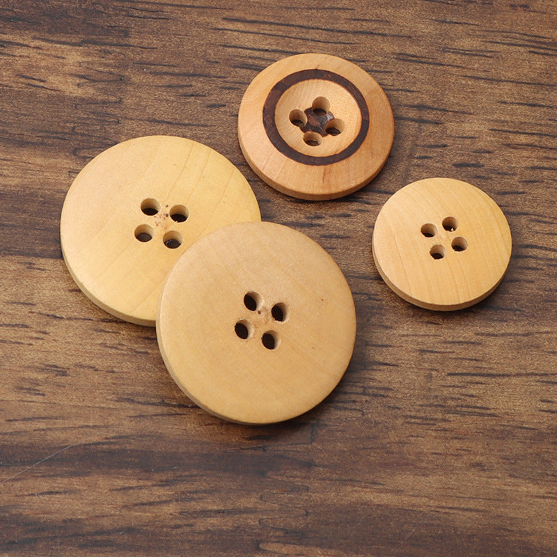 Set of round wooden buttons with four holes; some feature black-burned rings