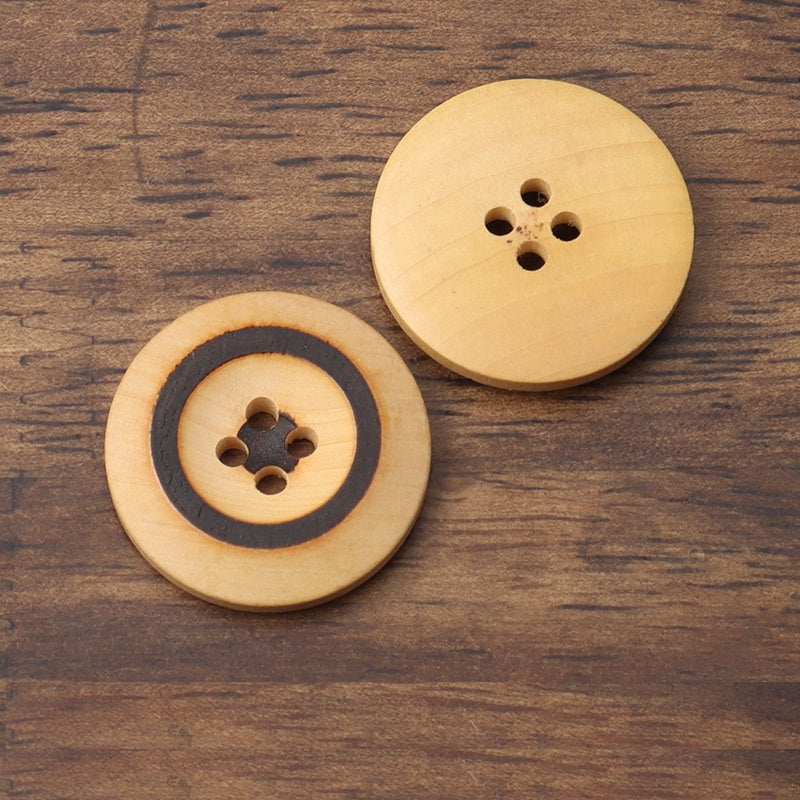 Two round light wood buttons with four holes; one has a black ring
