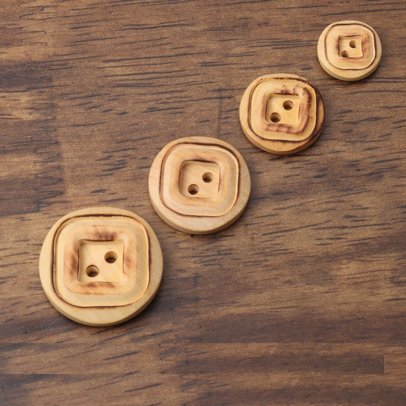 Round 2-hole wooden buttons showing square interior backs in light tan