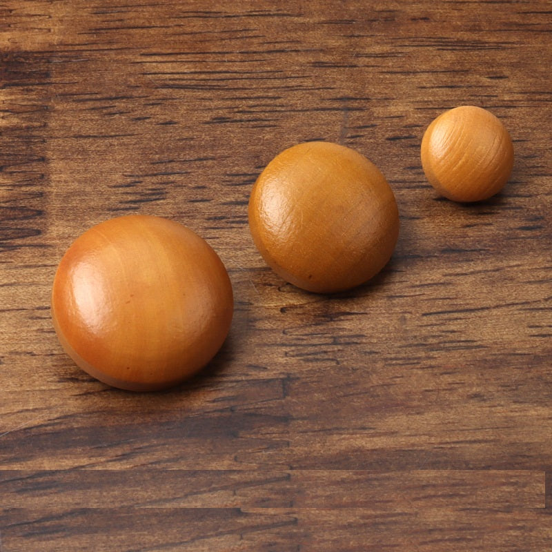 Three round brown painted wood buttons, front view