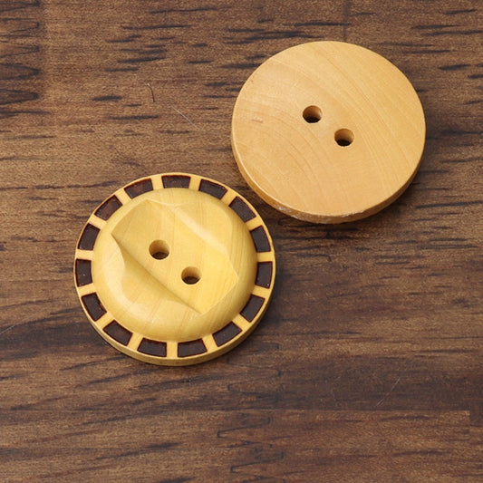 Two round 2-hole wood buttons with dark geometric border and natural grain