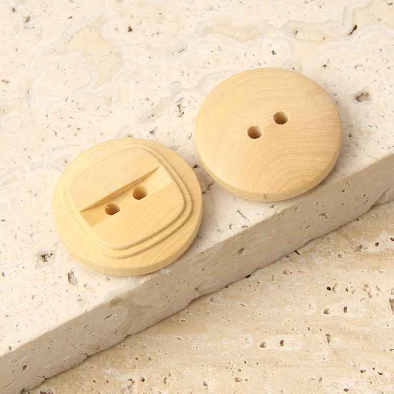 Two round natural poplar wood 2-hole buttons, beige, front faces