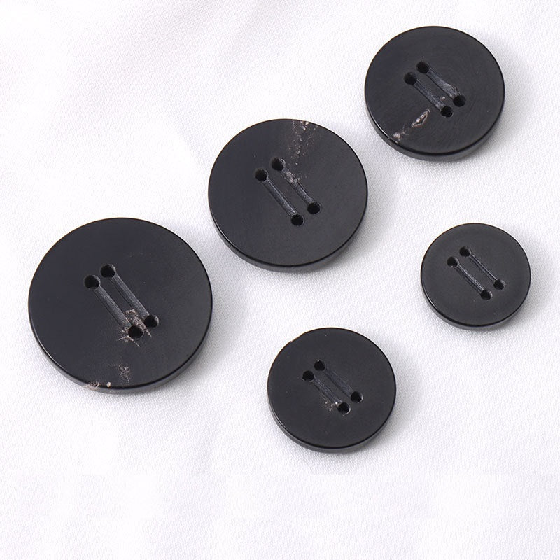 Five round black 4-hole horn buttons with double-groove shanks