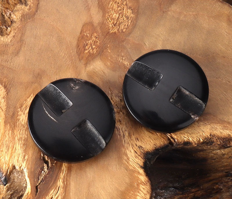 Two black convex horn buttons with concealed hole tabs