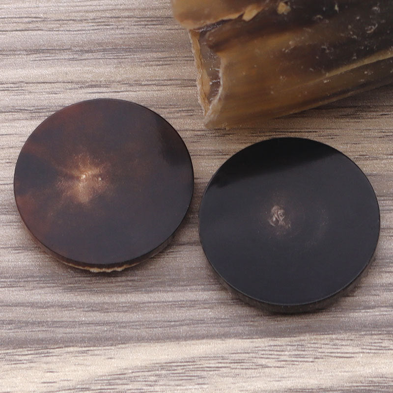 Round flat horn buttons in coffee and black tones, showing shanks from the back