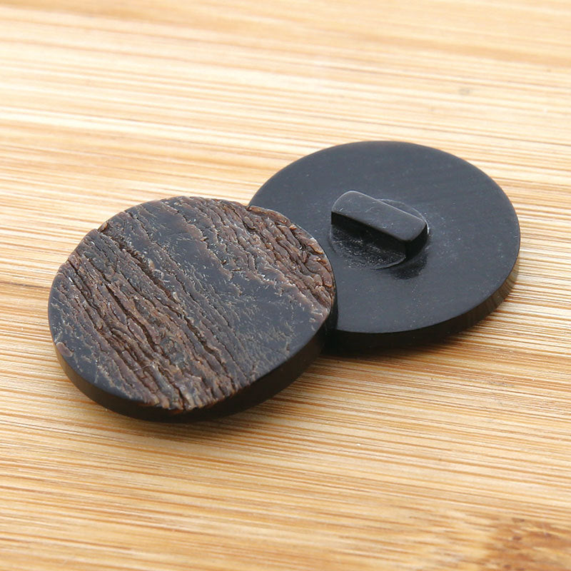 Round dark horn coat button with visible loop shank on the back; textured face