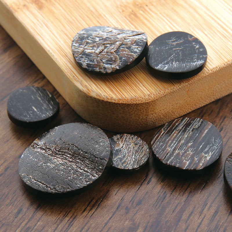 Round dark horn buttons with natural grain texture; shank backs visible