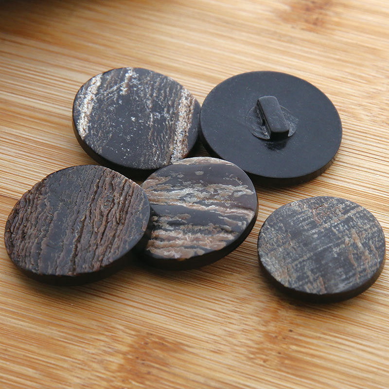 Assorted round dark horn buttons with textured fronts and shank backs