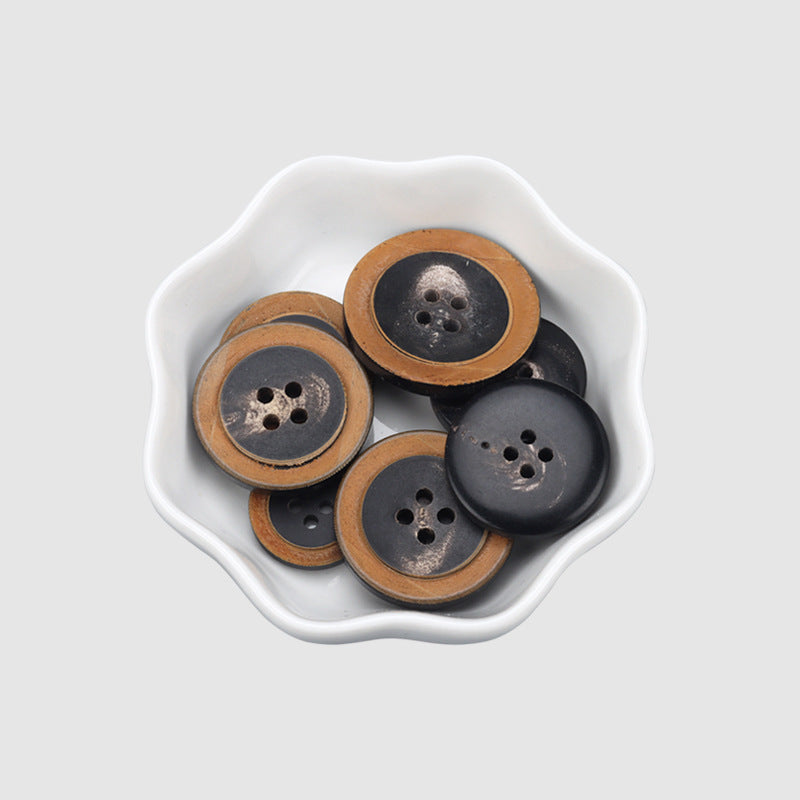 Black round four-hole buttons in a bowl, horn-look edging