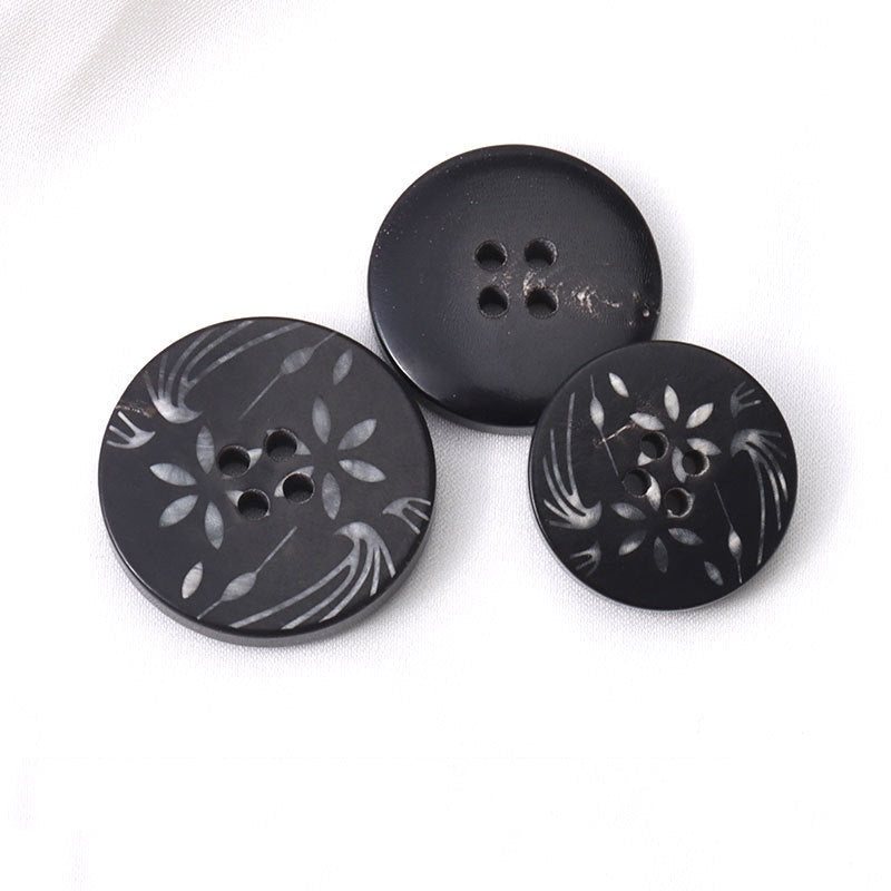 Set of black horn buttons: 4-hole fronts with white flower pattern, plain backs