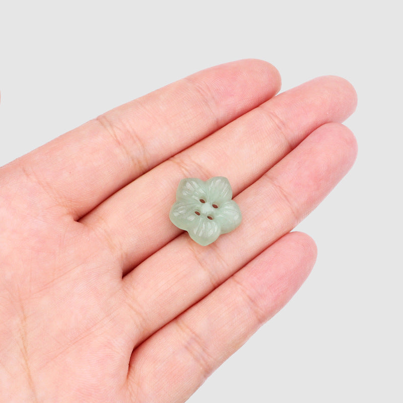 Light green jade petal flower button, four-hole design held in hand