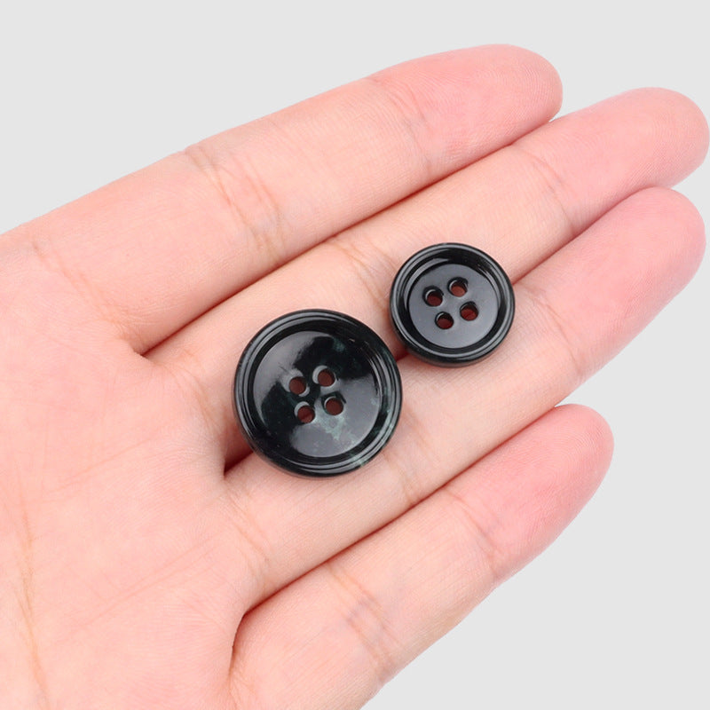 Black round 4-hole buttons held in hand, 4pcs, glossy finish