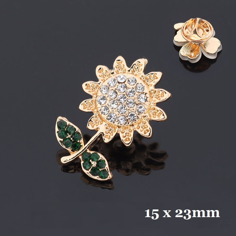 Golden snowflake-and-flower brooch with green rhinestone accents, 15x23mm
