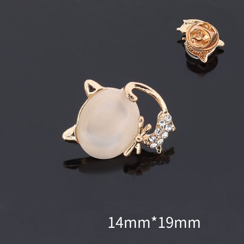 Golden cat-shaped brooch with white round center and tiny rhinestone accents, 14mmx19mm