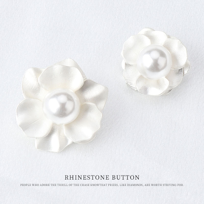 Two white floral buttons with pearl-like round center and flat shank back