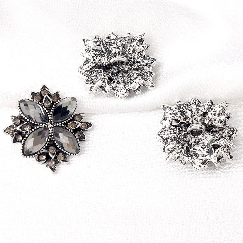 Set of three 23mm gunmetal-black floral rhinestone shank buttons with black stones