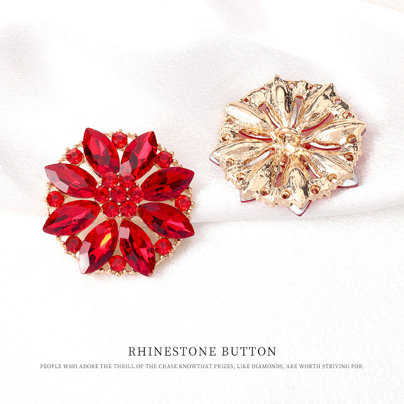 Red rhinestone floral button with gold-tone ornate backing, faceted crystal center