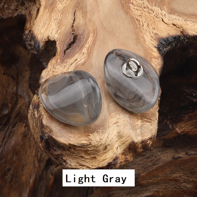 Two resin-look jade buttons with gold-tone metal loops, light gray teardrop shape