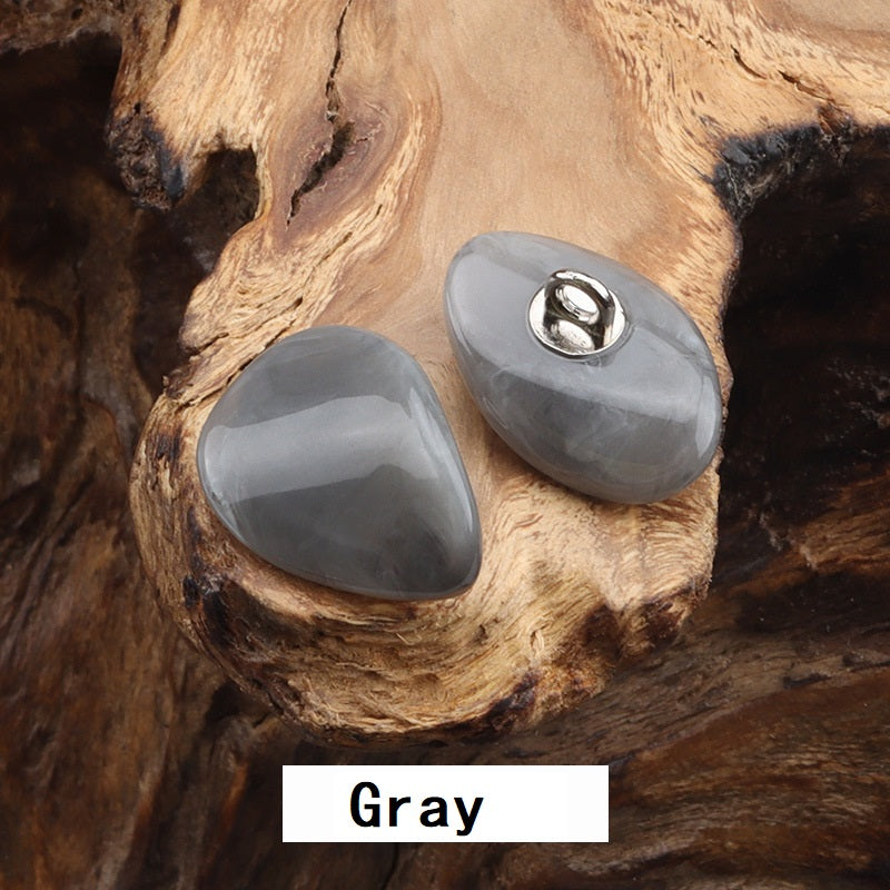 Two resin-look jade buttons with gold-tone metal loops, gray teardrop shape
