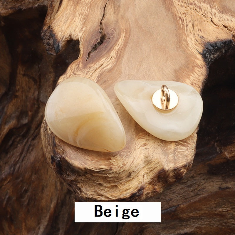 Two resin-look jade buttons with gold-tone metal loops, beige teardrop shape