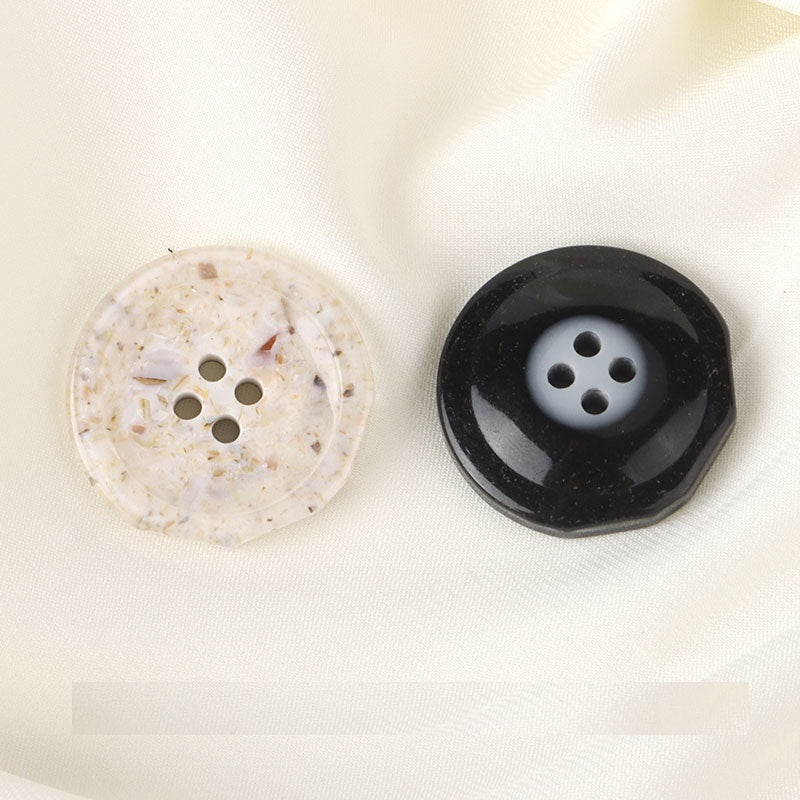 White and black four-hole resin rock buttons, round, each with four holes