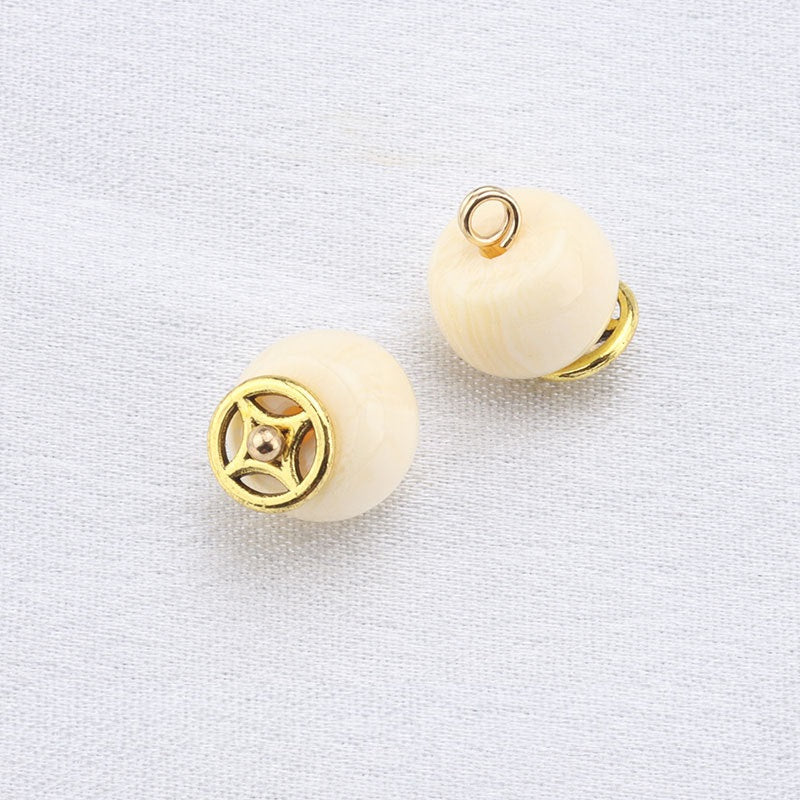 Beige round resin frog button with gold ring top and decorative gold medallion