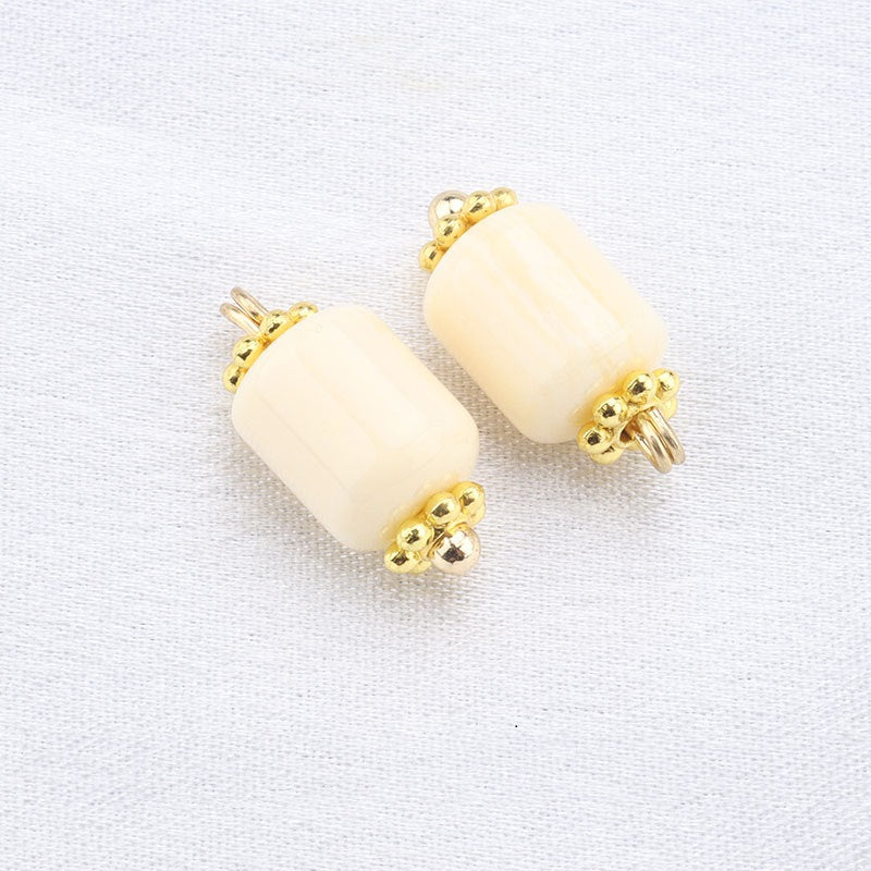 Beige resin frog button pair with gold surround and gold stud top and bottom
