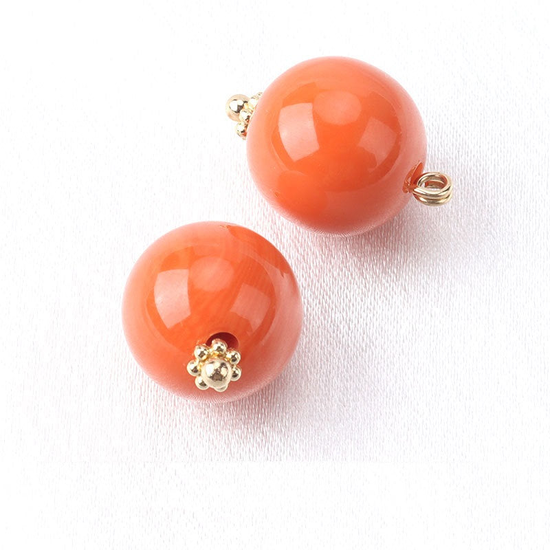 Orange resin bead buttons with flower base, gold-tone loop backs