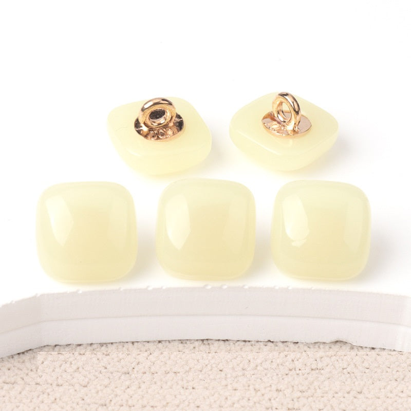 Cream square resin buttons with gold-tone shanks, glossy translucent tops