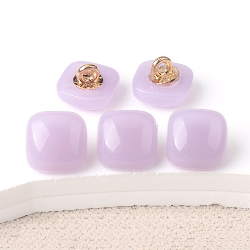 Lavender square resin buttons with gold-tone shanks on glossy translucent fronts