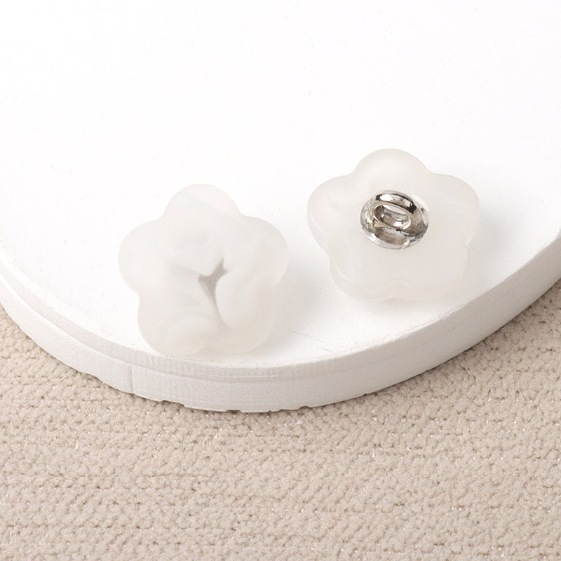 White resin flower-shaped shank buttons with metal loop, pair view
