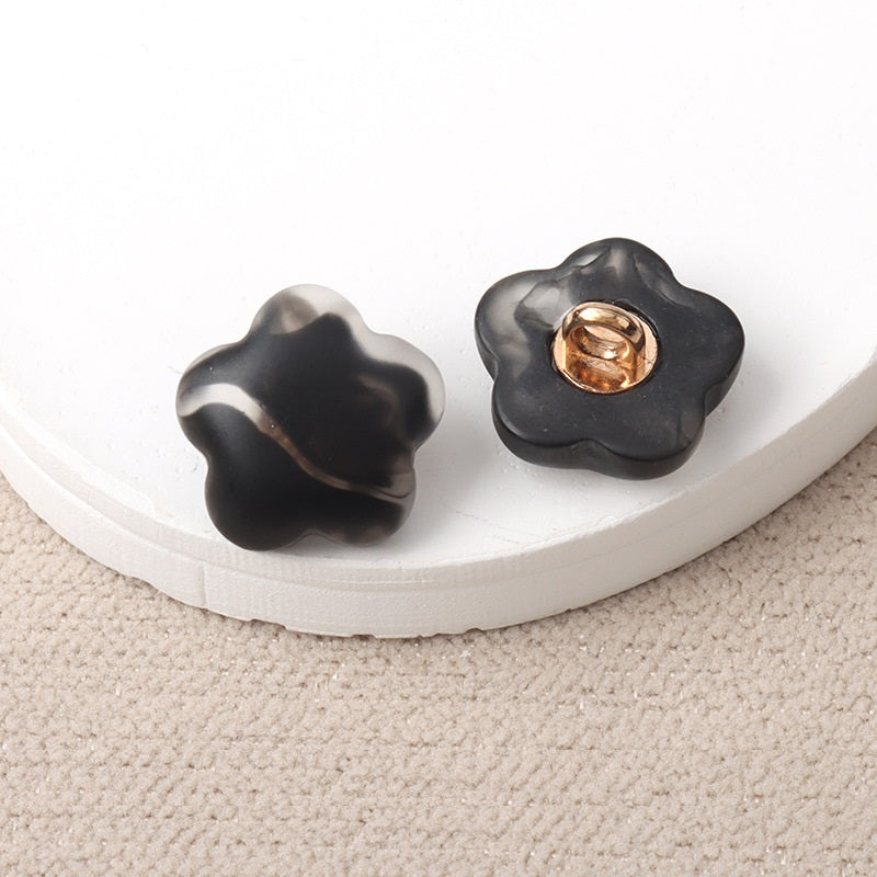 Black resin flower-shaped shank buttons with metal loop, pair view