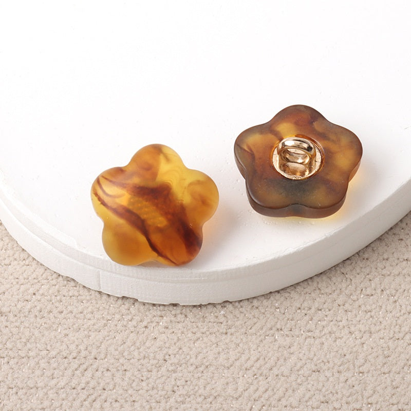 Amber resin flower-shaped shank buttons with metal loop, pair view