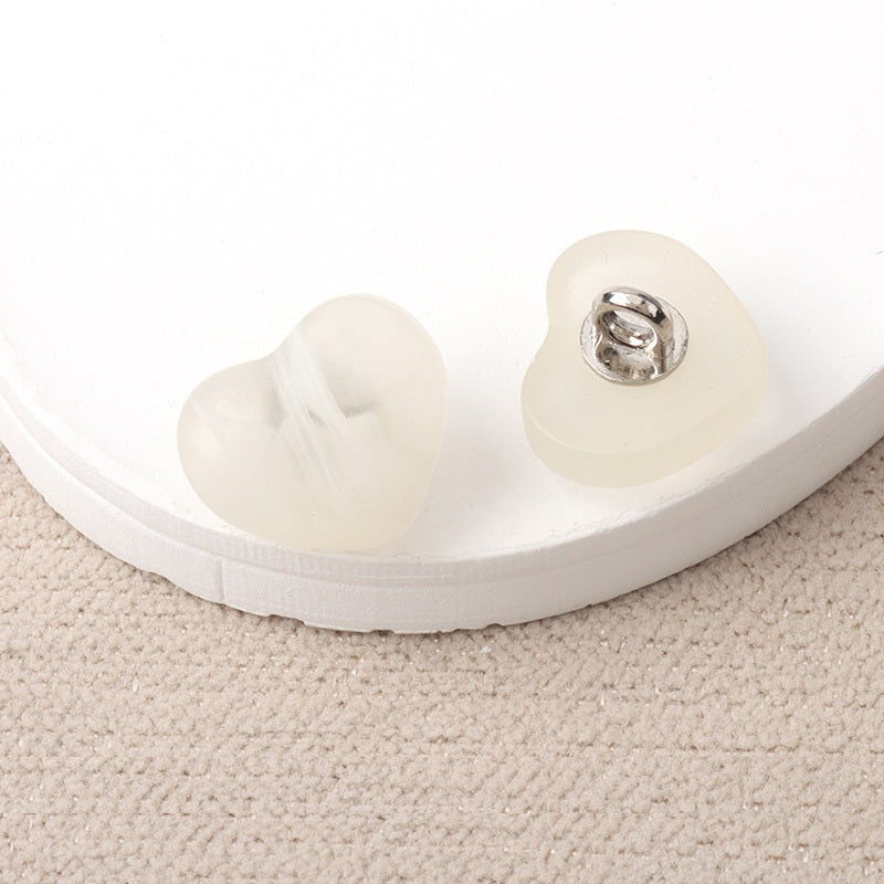 White resin heart-shaped shank buttons with metal loop, pair view