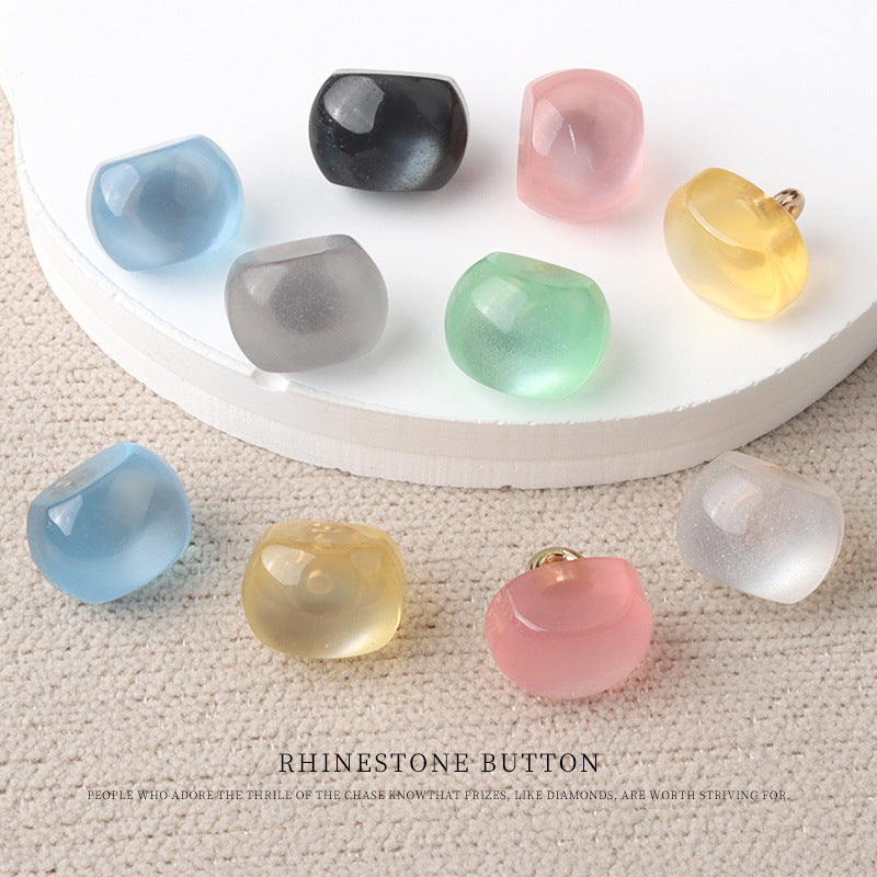 Assorted resin pearl buttons in black, pink, green, blue, and yellow tones with metal shanks