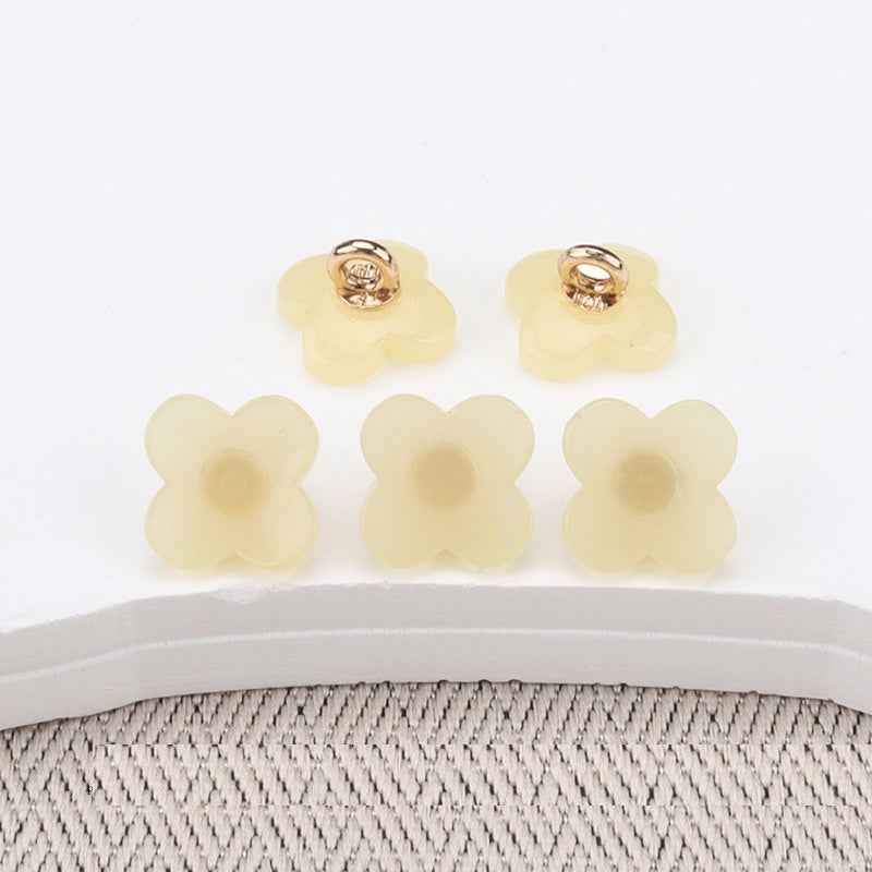 Flower-shaped resin buttons with high shank, pale yellow/cream, gold-tone loops