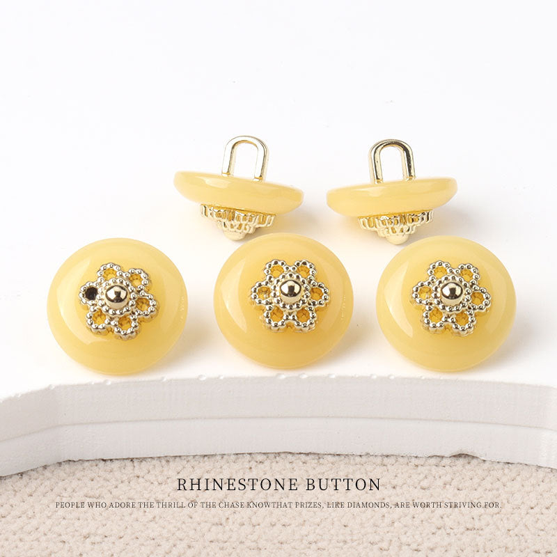 Round resin shank buttons, yellow finish with gold floral rhinestone centers, shank backs shown