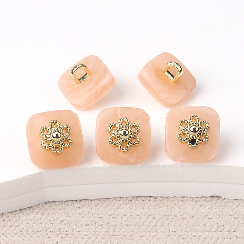 Square resin buttons with metal shanks, ornate silver center; pink.