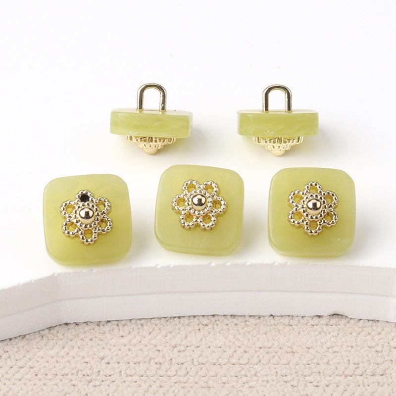 Square resin buttons with metal shanks, ornate silver center; green.